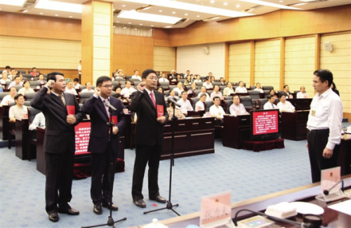 Three newly appointed officials take a solemn oath to China's Constitution in Hainan on November 26, 2014. (Photo: Hainan Daily/Li Chao)