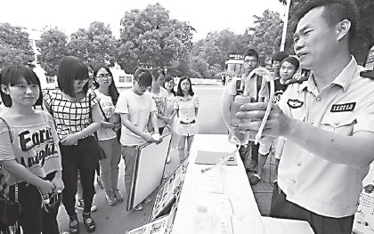 A police officer displays a drug-taking device during an anti-drug event at Jiangsu University in Zhenjiang, East China's Jiangsu province, on Sunday. (Yang Yu/for China Daily)