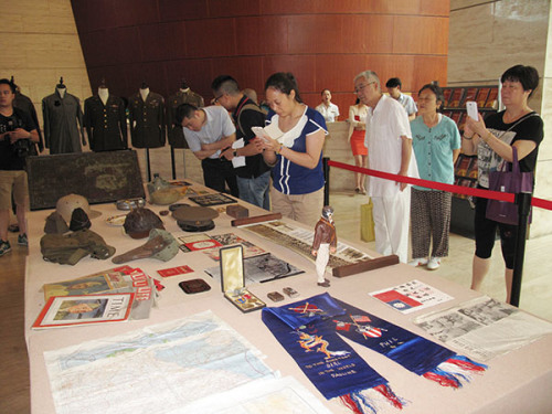 Visitors take an interest in artifacts donated by Pedro Chan, a Chinese American, at the Jinsha Site Museum in Chengdu. (Photo by Huang Zhiling/www.chinadaily.com.cn)
