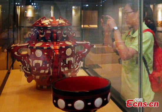 A visitor looks at an item at an exhibition about Beijings 3060 years of history in the Capital Museum in Beijing, June 24, 2015. (Photo: China News Service/Song Jihe)
