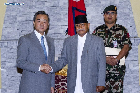 Chinese Foreign Minister Wang Yi (L) shakes hands with President of Nepal Ram Baran Yadav, in Kathmandu, Nepal, June 24, 2015. Wang Yi arrived at Kathmandu Wednesday. He will attend a conference of international donors in Kathmandu on June 24 and 25. (Xinhua/Pratap Thapa)