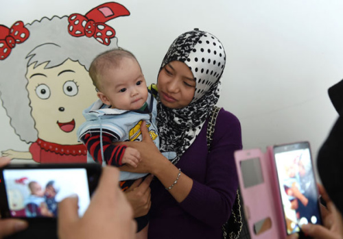 A volunteer cares for a baby who was rescued from child traffickers in November. The child was taken to this welfare center in Kaiyuan, Yunnan province. (Photo/Xinhua)