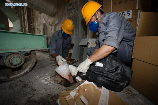 Staff members destroy the confiscated drugs in a cement factory in the outskirt of Nanjing, capital of east China's Jiangsu Province, June 24, 2015. (Photo: Xinhua/Li Xiang)