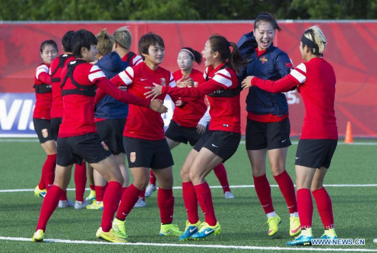 Players of China share a light moment while training ahead of their 2015 FIFA Women's World Cup quarterfinal match against the United states in Ottawa, Canada, June 23, 2015. (Photo: Xinhua/Zou Zheng)