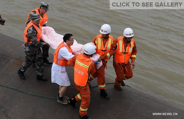 A survivor is saved from the overturned passenger ship in the Jianli section of the Yangtze River in central China's Hubei Province June 2, 2015. (Xinhua/Xiao Yijiu) 