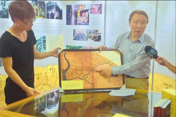 Professor Su Zhiliang (right) of Shanghai Normal University points to a map that shows the 166 comfort houses set up in Shanghai by invading Japanese troops. (Photo/Ti Gong)