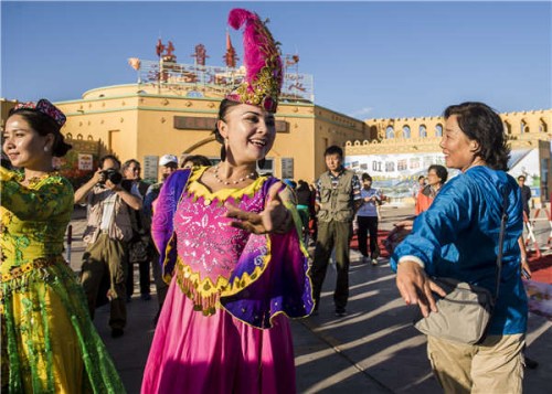 Local Uygur women greet visitors with dancing and singing in Turpan, in the Xinjiang Uygur autonomous region. (Photo provided to China Daily)