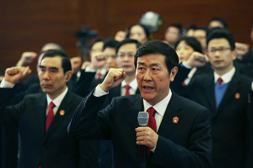 Shen Deyong, executive vice-president of the Supreme People's Court, takes the lead in making an oath to the Constitution in Beijing in December. Wang Jing/China Daily