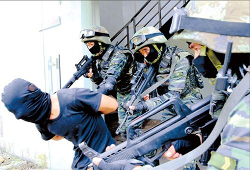 Armed police officers arrest a terrorist yesterday during an exercise in the Pudong New Area. About 200 personnel, two assault boats, four armed vehicles and a helicopter from an anti-terrorist unit took part in the drill, which was staged to test the citys capabilities in dealing with such a threat. (Photo/Xinhu)a