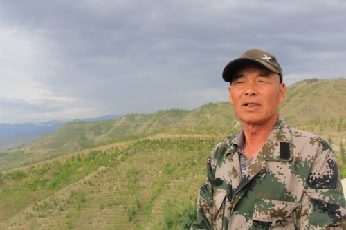Xu Xiuqi, 63, is a retired forester who was reemployed to help plant trees in the barren mountains in Altay, Xinjiang Uygur autonomous region.(Photo by Xu Wei /China Daily)