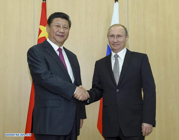 Chinese President Xi Jinping (L) shakes hands with his Russian counterpart Vladimir Putin in Ufa, Russia, July 8, 2015. (Xinhua/Li Xueren) 