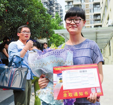 Zhang Yixiang shows her enrollment notice from University of Electronic Science and Technology of China in Chengdu, Sichuan province, on Tuesday. The notice was the first received in the province this year. (Lyu Jia/for China Daily)