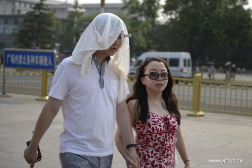 A man wears a towel on his head to beat the heat in Beijing, capital of China, July 12, 2015. Beijing issued this summer's first heat alert on Sunday as the maximum temperature in the Chinese capital soared above 40 degrees celsius. (Photo: Xinhua/Song Jiaru)