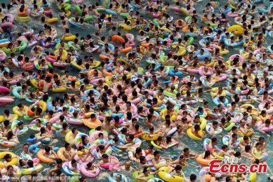 Tourists flock to a water resort at Dead Sea in Daying county, Suining city, Southwest China's Sichuan province, July 11, 2015. More than 8,000 people squashed into the 30,000-square-meter pool as temperatures reached 35 degrees Celsius. Chinese netizens joked the crowded scene looked like “boiling dumplings”. (Photo/CFP)