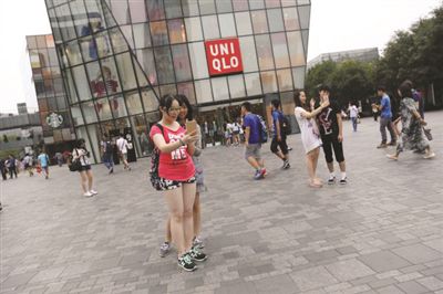 People take photos in front of a Uniqlo outlet in Sanlitun, Beijing, on July 15 after a sex video taken in a fitting room in the store went viral online.(Photo/Weibo)