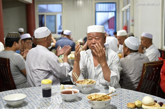 Muslims prepare to have the fast-breaking meal after sunset at Xihuan Mosque during the Muslim fasting month of Ramadan in Yinchuan City, capital of northwest China's Ningxia Hui Autonomous Region , July 3, 2015. (Photo: Xinhua/Wang Peng)