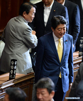 Japanese Prime Minister Shinzo Abe (R) thanks for passing the controversial security bills at the lower house of the nation's Diet in Tokyo, Japan, on July 16, 2015. (Photo: Xinhua/Ma Ping)