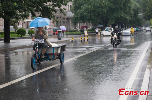 Beijing sees more rainfalls on Friday, July 17, 2015, as local weather bureau issues a yellow alert for rainstorm and a blue alert for thunder and lightning. China has a four-tier color-coded weather warning system, with red representing the most severe weather, followed by orange, yellow and blue. (Photo: China News Service/Li Qing)