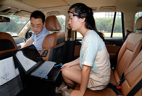 A driver wears equipment to control a car by her brain during an experiment last week at Nankai University in Tianjin. (Chen Feng/For China Daily)