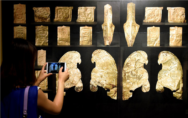 A visitor photographs ornamental gold foil at the Gansu Provincial Museum in Lanzhou, capital of Gansu province, on Monday. The exhibits, which date back more than 2,000 years, have been recently retrieved from France after being stolen and sold overseas in the 1990s. (Photo by Fan Peishen/Xinhua)