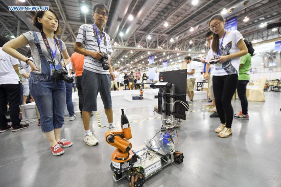 A student from the University of Science and Technology of China (USTC) controls Kuka Worker during the Robocup 2014 competition in Hefei, capital of east China's Anhui Province, July 20, 2015. Four teams of the USTC participated in the four-day competition that kicked off here on July 19. (Photo: Xinhua/Zhang Duan) 