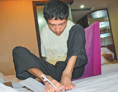 Peng Chao writes with one foot on his bed in a hotel room in Chengdu, Sichuan province, in early July. (Huang Leran/for China Daily)