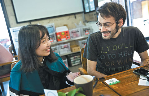 A language teacher from Italy (right) chats with a student who plans to study in Milan. (Photo by Chen Xiaodong/for China Daily)