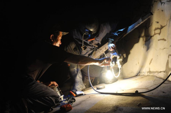 Rescuers install lights at the well entrance of Xuxiang mine in Xing'an District of Hegang City, northeast China's Heilongjiang Province, July 21, 2015. (Photo: Xinhua/Wang Song)
