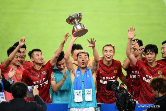 Zheng Zhi (C) of Guangzhou Evergrande celebrates with the trophy after winning the friendly football match against Bayern Munich in Guangzhou, capital of south China's Guangdong Province, July 23, 2015. Guangzhou Evergrande beat Bayern Munich 5-4 after the penalty shootout. (Photo: Xinhua/Liu Dawei)