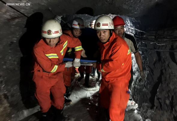 Rescuers carry workers out of a cave-in stannum mine in Lianghe County of Dehong Prefecture, southwest China's Yunnan Province, July 27, 2015. Eleven people who were trapped after a cave-in in a mine pit here Saturday all got rescued in the early morning of Sunday. (Photo: Xinhua/Huang Zhaokui) 