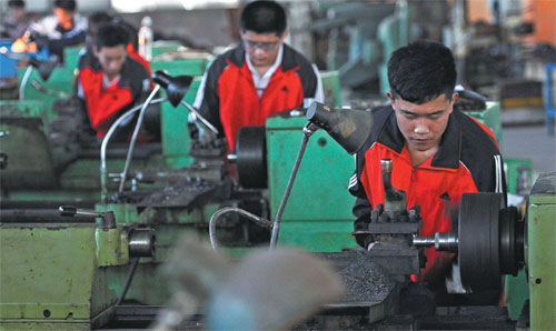 Students at a vocational school in Zouping, Shandong province, learn how to operate a lathe. (Dong Naide/for China Daily)