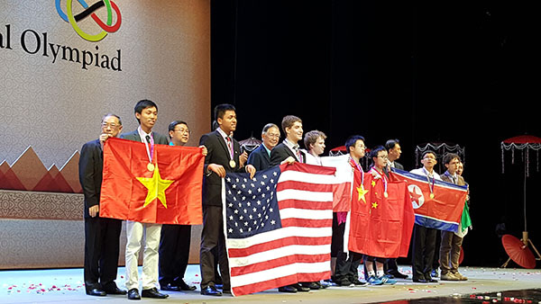 Top teams participated in the International Mathematical Olympiad pose on stage with their national flags on July 15 in Chiang Mai, Thailand. (Provided to China Daily)