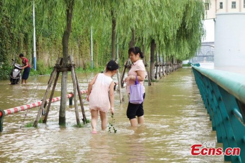 Pedestrians brave floodwater on a road in Liuzhou city, Southwest Chinas Guangxi Zhuang autonomous region, July 28, 2015. Rainstorms and floods have affected 262,700 people in Guangxi and 12,700 have been evacuated to safety, a local source says. (Photo: China News Service/Huang Weiming)