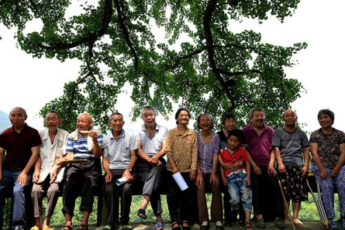 Senior citizens wait for their photos to be taken at a village in Huaying, Sichuan province, in June. (China Daily/Qiu Haiying)