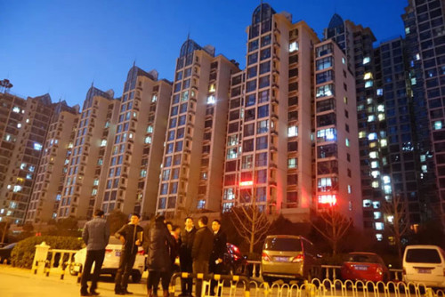 Real estate agents talk with potential clients at the entrance to a residential compound in Yanjiao, Hebei province, Jan 11, 2015. (Photo by Song Wei/chinadaily.com.cn)