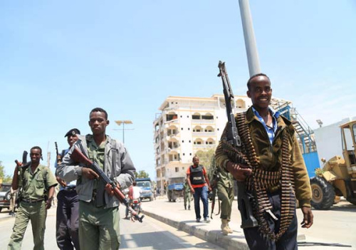 Somali soldiers stand near the ruins of the Jazeera Palace Hotel after Sunday's suicide bombing attack in Mogadishu, capital of Somalia, July 29, 2015. (Photo by Hou Liqiang/chinadaily.com.cn)