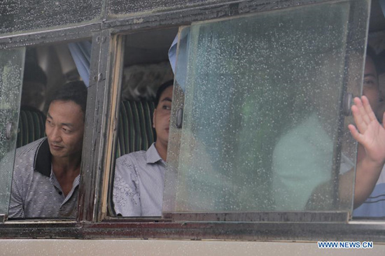 Chinese loggers look out from the bus window after being freed from Myitgyina Jail, July 30, 2015. The Myanmar government on Thursday granted an amnesty to 6,966 prisoners including 155 detained Chinese loggers. (Xinhua/Myitkyinabrang)