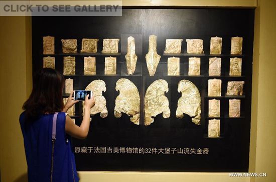 A woman visits a public exhibition of Chinese cultural relics returned by French private collectors, at Gansu Provincial Museum in Lanzhou, capital of northwest China's Gansu Province, July 20, 2015. (Photo: Xinhua/Fan Peishen)