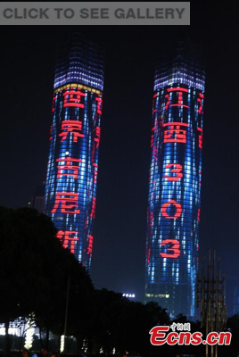 Twin towers of Nanchang Greenland Central Plaza, which measure 303 meters high, celebrate making a Guinness world record for the largest LED screen, in Nanchang city, Jiangxi province, July 28, 2015. (Photo: China News Service/Wang Jian)