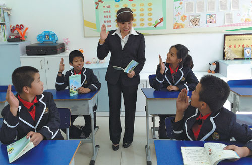 Li Xiaoyu, who specializes in teaching children with disabilities, interacts with students during a Chinese class at Jixi Special Education School in Heilongjiang province last year.  (Provided to China Daily)
