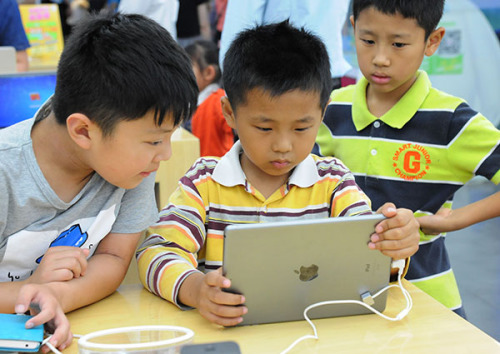 Children read e-books in a bookstore in Suzhou, Jiangsu province. E-reading has become part of people's daily lives. (Wang Jianzhong/For China Daily)