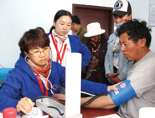 Physicians from Beijing check the blood pressure of a middle school teacher in Chali town in the Aba Tibetan and Qiang autonomous prefecture. (Li Yang/China Daily)