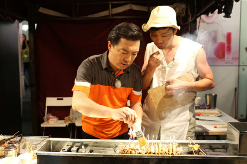 Chinese Alist actor Huang Bo (left) appears in a new TV reality show Go Fighting as a street vendor selling shashlik. (Photo/Provided To China Daily)