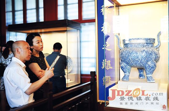 Visitors look at a piece of porcelain at the Palace Museum.