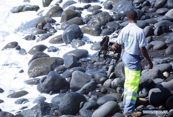 A searcher searches the Saint Andre Beach of France's overseas island La Reunion in the Indian Ocean, where the first piece of debris from the missing Malaysian Airlines flight MH370 was found, on Aug. 10, 2015. France on Aug. 7 announced that hunts for more MH370 debris will continue for at least a week off la Reunion after a wing section was spotted near the island. (Photo: Xinhua/Zhang Chuanshi)