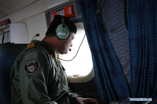 A crew member of Mauritian Coast Guard conducts search operations over the surrounding waters of Mauritius on Aug. 10, 2015. (Photo: Xinhua/Pan Siwei)