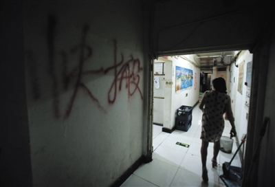 Words move out quickly wrriten with red paint is seen on the wall of a basement in Beijing's West Wangjing residential district. (Photo: Beijing News/Peng Ziyang)