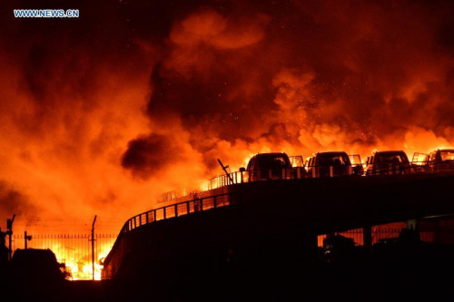 Photo taken on Aug. 13, 2015 shows the burning scene of the explosion site in the Binhai New Area in north China's Tianjin Municipality. The death toll from a Tianjin warehouse blast Wednesday night has climbed to 17, according to rescuers. Another 32 people were critically injured and 283 people are under observation in hospital. (Photo/Xinhua)