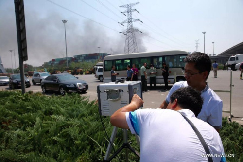 Staff members of Tianjin Environment Monitoring Center monitors air quality near the explosion site in Binhai New Area of Tianjin, north China, Aug. 13, 2015. (Photo: Xinhua/Jin Liwang)