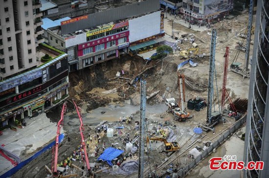 Workers fill a cave-in with cement at a subway construction site in Dongguan city, South Chinas Guangdong province, Aug 13, 2015. One worker died after a 300-square-meter area collapsed at the site. A car was also swallowed into the hole during the collapse on Wednesday. The accident also caused water and gas pipelines to burst. (Photo: China News Service/Chen Jimin)